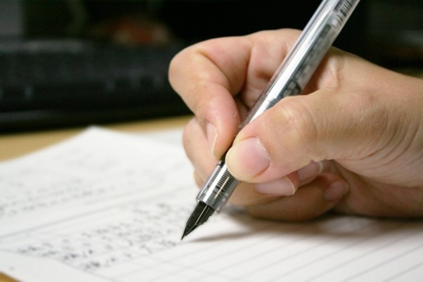 履歴書にボールペンで記入する様子