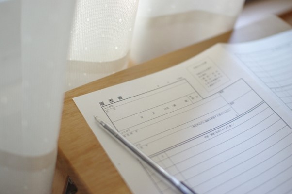 カーテン横の机上の履歴書